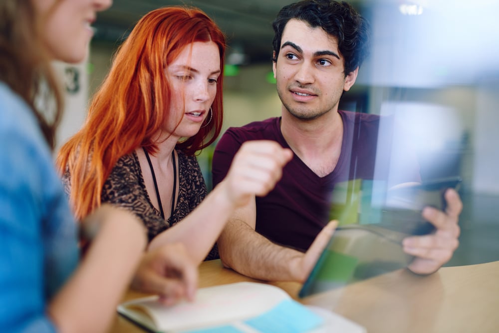 Unposed group of creative business people in an open concept office brainstorming their next project.